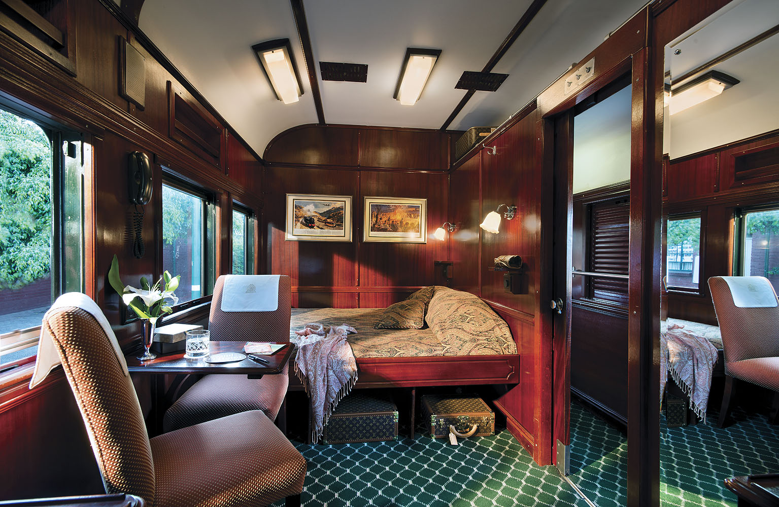 Komfortable Suite mit edlen Holzvertäfelungen im Luxuszug Rovos Rail in Südafrika.