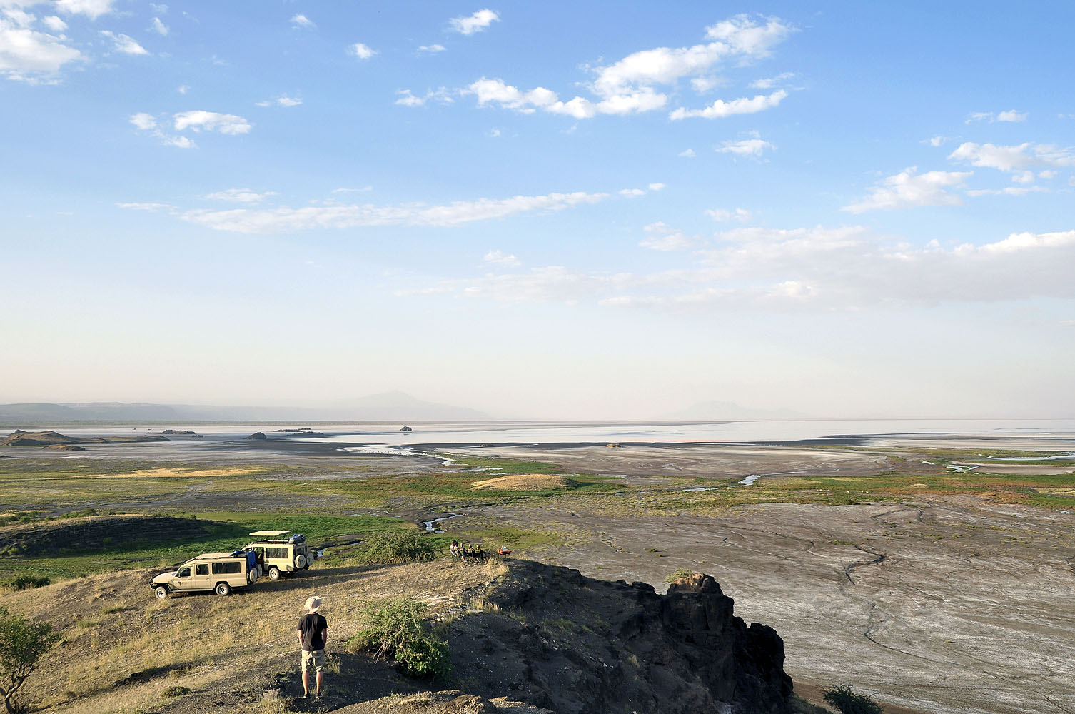 Aussichtspunkt über den Lake Manyara in Tansania mit Safari-Fahrzeugen am Rand des ostafrikanischen Grabenbruchs.