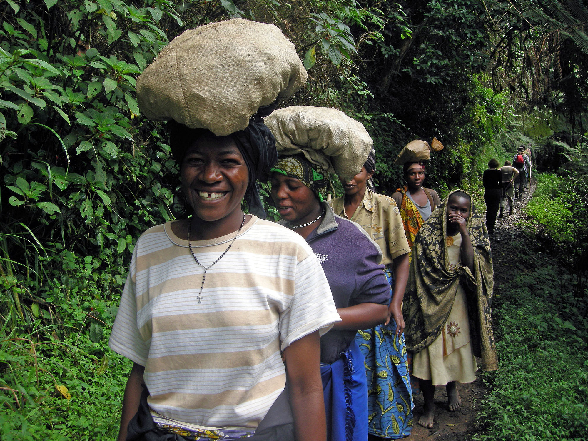 Dorfbewohner tragen Waren auf einem Waldpfad am Rand des Bwindi Impenetrable Nationalparks in Uganda.